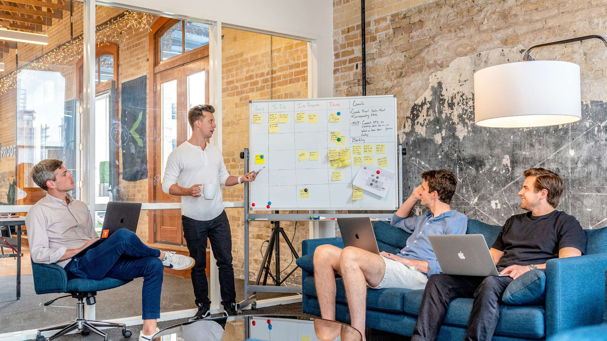 All-Asian group of East and Southeast Asian senior professionals collaborating around laptops in a modern Singapore technology startup office; every visible person is Asian and no Western people are present